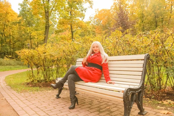 genç güzel artı boyutu kafkas kadın sonbahar parkta bankta oturur