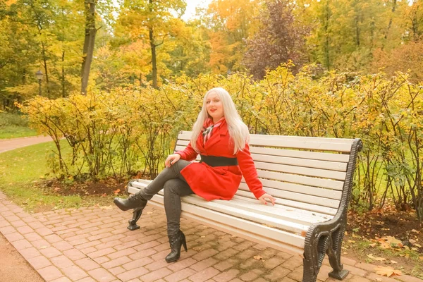 genç güzel artı boyutu kafkas kadın sonbahar parkta bankta oturur