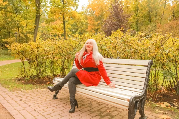 genç güzel artı boyutu kafkas kadın sonbahar parkta bankta oturur