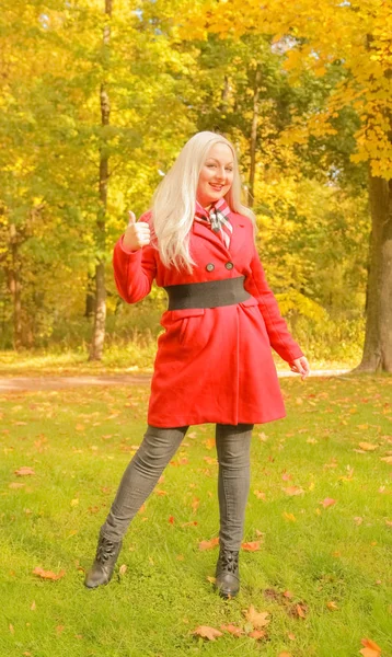Joven bonita más tamaño caucásico rubia mujer en rojo lana abrigo paseos en otoño parque — Foto de Stock