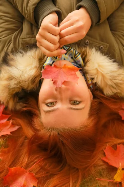 Молодая красивая белая женщина плюс размер лежит на земле в осеннем парке вид сверху — стоковое фото