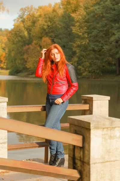 Молодая симпатичная белая женщина плюс размер прогулки возле озера в осеннем парке — стоковое фото