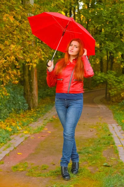 Jeune jolie plus taille femme caucasienne promenades avec parapluie rouge dans le parc d'automne — Photo