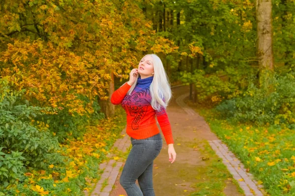 Unga pretty plus size kaukasiska kvinna i orange mode tröja promenader i höst parken — Stockfoto