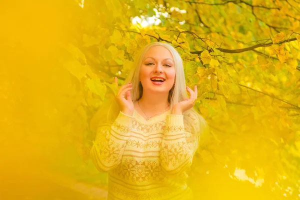 Junge hübsche Plus-Size-Kaukasierin im weißen Pullover spaziert durch Herbstpark — Stockfoto