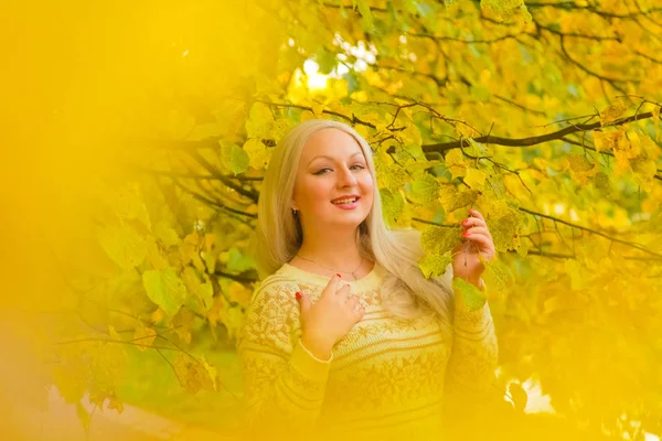 Jonge mooie plus size Kaukasische vrouw in witte trui wandelingen in herfst Park — Stockfoto