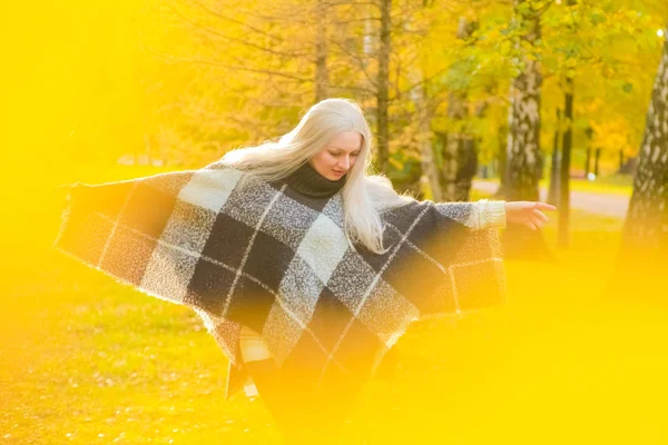 Mladá krásná plus velikost Kavkazská žena kostkované vlna Poncho procházky v podzimním parku — Stock fotografie