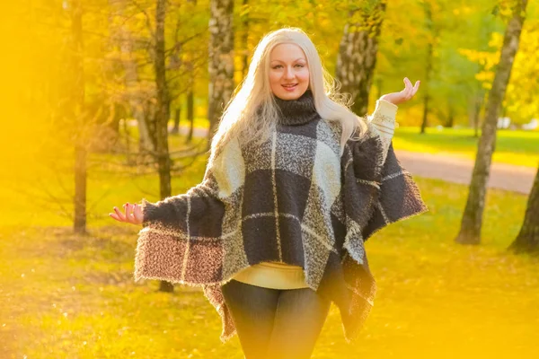 Jonge mooie plus size Kaukasische vrouw geruite wollen poncho wandelingen in herfst Park — Stockfoto