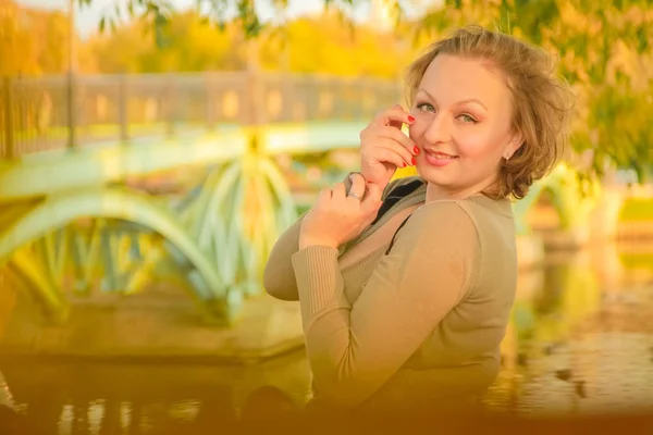 Jeune jolie plus taille femme caucasienne promenades dans le parc d'automne — Photo