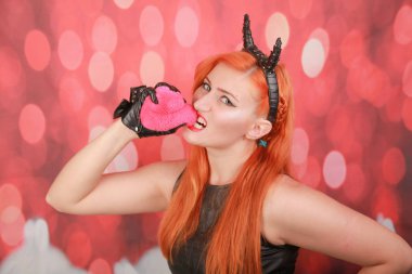 Kırmızı arka plan üzerinde kalp şekli ile pembe peluş oyuncak ile Devil kız