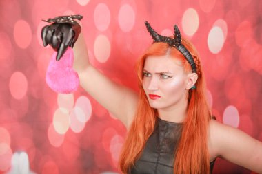 Kırmızı arka plan üzerinde kalp şekli ile pembe peluş oyuncak ile Devil kız