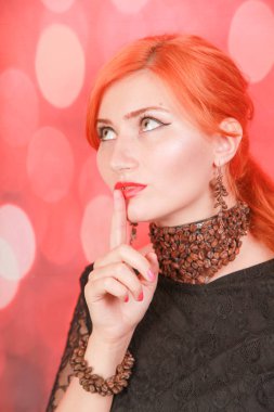 Kadın kahve lezzetli aroması zevk ve kırmızı noel arka plan üzerinde kahve çekirdekleri ile takı giymek