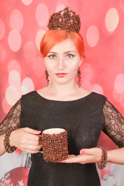 Mujer disfrutando sabroso aroma de la taza de café y usar joyas con granos de café sobre fondo rojo de Navidad — Foto de Stock