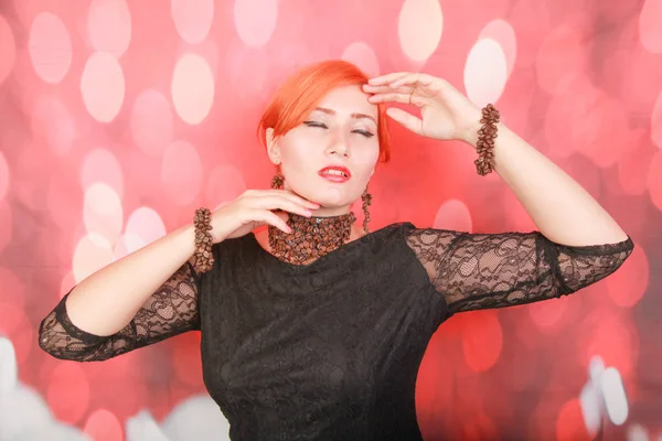 Kadın kahve lezzetli aroması zevk ve kırmızı noel arka plan üzerinde kahve çekirdekleri ile takı giymek