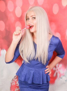 Kırmızı xmas arka plan üzerinde lolipop şeker ile peplum elbise Noel kadın