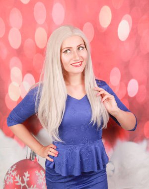 kırmızı xmas arka plan üzerinde mavi peplum elbise güzel sarışın kadın