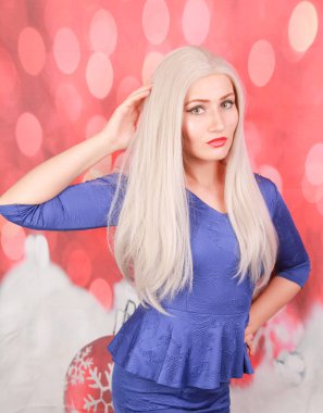 kırmızı xmas arka plan üzerinde mavi peplum elbise güzel sarışın kadın