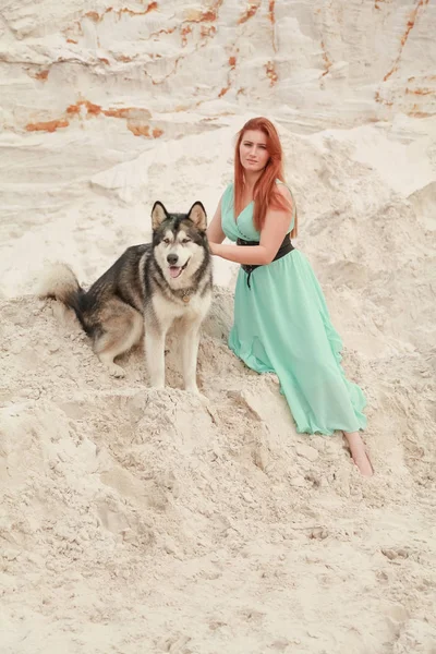 Забавна концепція найкращих друзів. Щаслива молода жінка гуляє в пустелі з великим собакою Маламут на відкритому повітрі — стокове фото