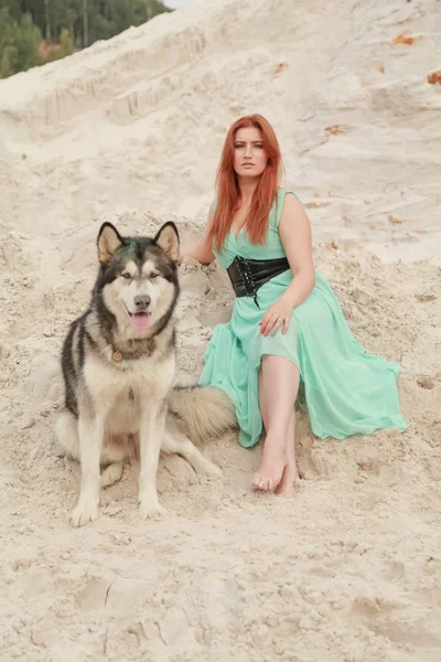 Забавна концепція найкращих друзів. Щаслива молода жінка гуляє в пустелі з великим собакою Маламут на відкритому повітрі — стокове фото