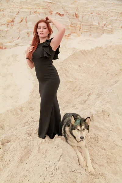 Drôle de concept de meilleurs amis. Heureuse jeune femme marche dans le désert avec un gros chien malamute à l'extérieur — Photo