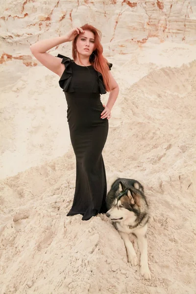 Drôle de concept de meilleurs amis. Heureuse jeune femme marche dans le désert avec un gros chien malamute à l'extérieur — Photo