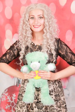 Oyuncak ayı tüm kızlar için en iyi arkadaştır. yeşil oyuncak ayı oyuncak ile güzel kıvırcık sarışın