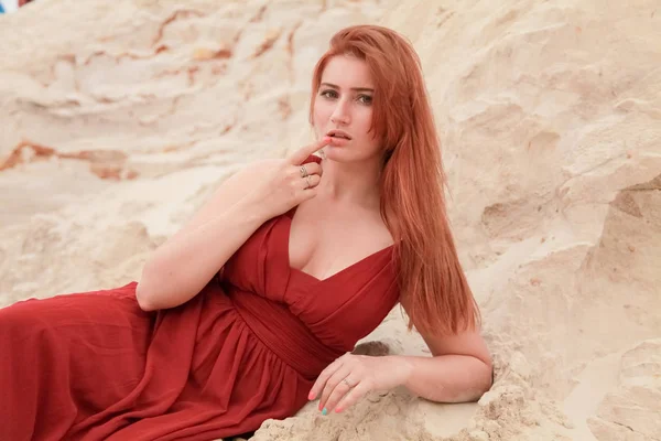 Молода красива кавказька жінка, що лежить наодинці в пустельному ландшафті з піском. — стокове фото