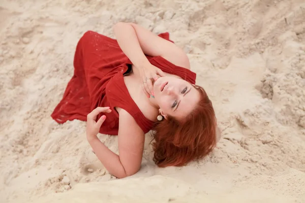 Jeune belle femme caucasienne couchée seule dans un paysage désertique avec du sable . — Photo