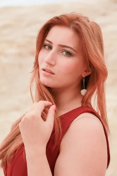 Porträt einer jungen schönen kaukasischen rothaarigen Frau, die in einer Wüstenlandschaft mit Sand posiert. — Stockfoto