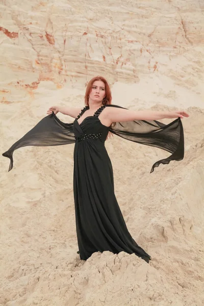 Siyah şifon elbiseli genç güzel Beyaz kadın kum ile çöl manzara poz.