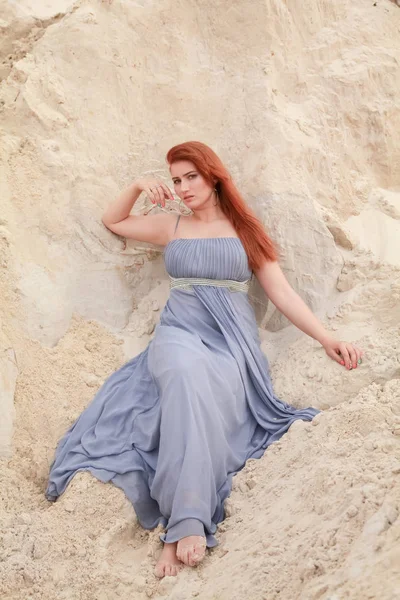 Молода красива кавказька жінка в вечірній shiffon плаття позує в пустельний пейзаж з піском. — стокове фото