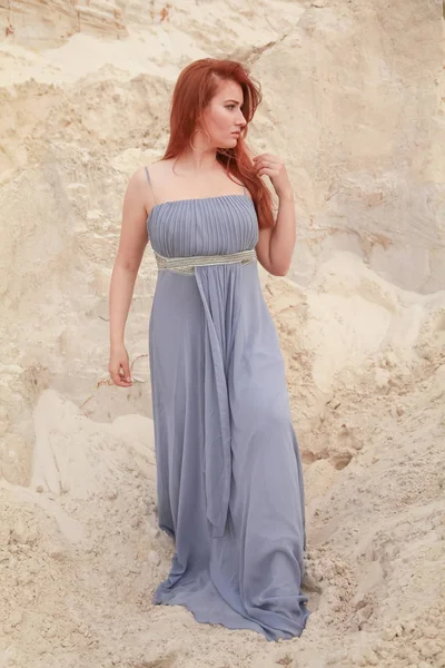 Jeune belle femme caucasienne en robe shiffon du soir posant dans un paysage désertique avec du sable . — Photo