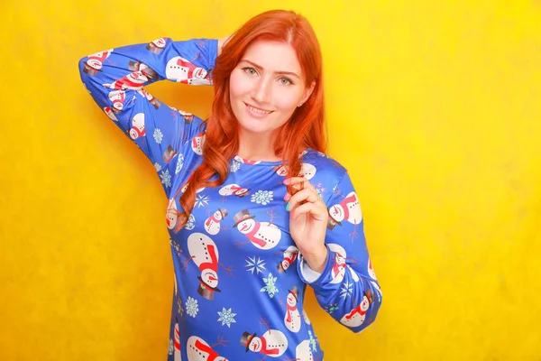 Careless dreamy attractive lady with red hair wearing blue funny christmas dress on yellow bright studio background — Stock Photo, Image