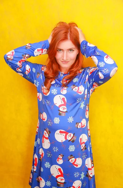 Dama atractiva soñadora descuidada con el pelo rojo usando azul divertido vestido de Navidad en fondo amarillo brillante estudio — Foto de Stock