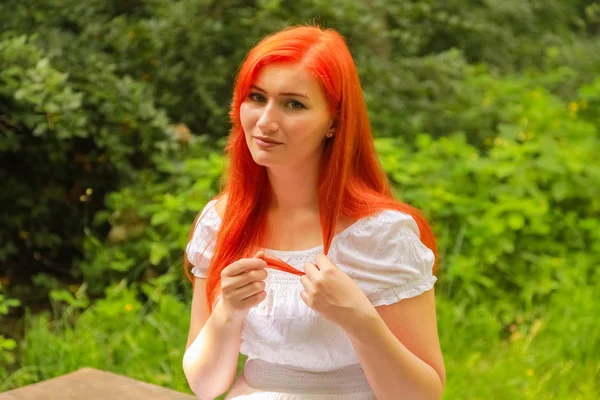 Bonita menina de cabelo vermelho andando em vestido de algodão branco no parque — Fotografia de Stock