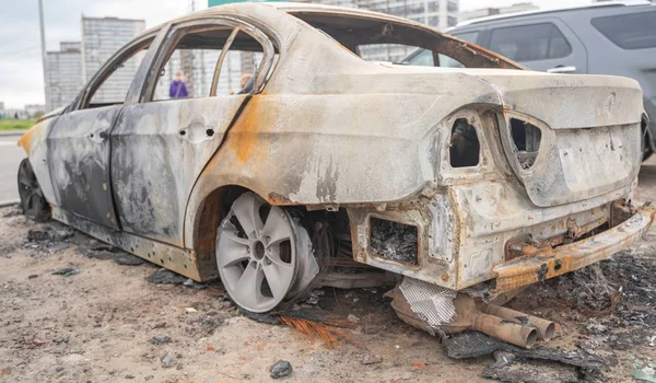 Carro após fogo posto deliberado. veículo destruído depois de um incêndio derretido está na rua . — Fotografia de Stock