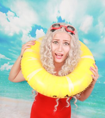 Plajda etkilendim cankurtaran işleri, insanları kurtarmak için lifebuoy kullanır, pinup kırmızı spandex genel yüzme giyer, kapalı duruyor, utandım hissediyor. Omg ve su aktiviteleri kavramı