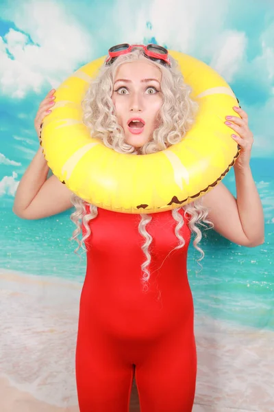 Plajda etkilendim cankurtaran işleri, insanları kurtarmak için lifebuoy kullanır, pinup kırmızı spandex genel yüzme giyer, kapalı duruyor, utandım hissediyor. Omg ve su aktiviteleri kavramı