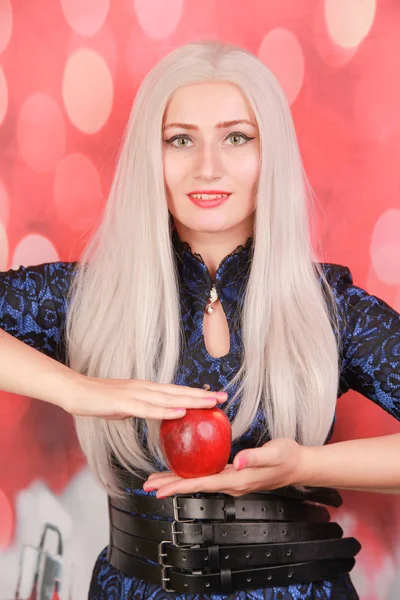 Blondine plus Größe hungriges Mädchen mit rotem Apfel auf rotem Weihnachtshintergrund träumt vom perfekten Körper im neuen Jahr — Stockfoto