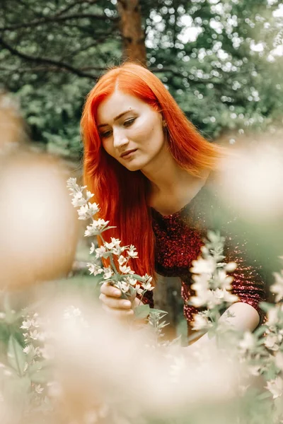 Mulher de cabelos vermelhos em cor de cereja vestido de noite andando no parque da cidade fundo e desfrutar de verão — Fotografia de Stock