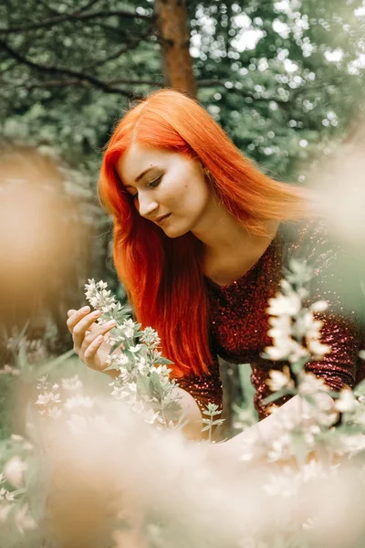 kiraz rengi gece elbisesi kırmızı saçlı kadın şehir parkı arka planda yürüyüş ve yaz keyfini çıkarın