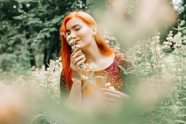 kiraz rengi gece elbisesi kırmızı saçlı kadın şehir parkı arka planda yürüyüş ve yaz keyfini çıkarın