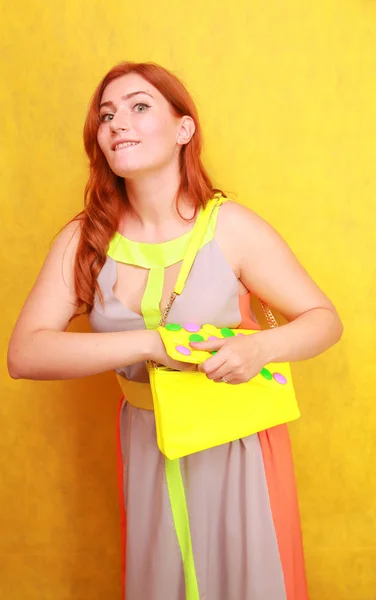 Jolie fille rousse en robe d'été lumineuse avec sac en cuir brillant jaune — Photo
