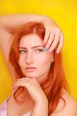 sadece sarı arka plan üzerinde pembe ipek elbise güzel güzellik kırmızı saçlı kadın. oyuncu artı boyutu kızıl saçlı yetişkin kız.