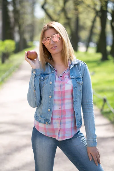 청바지 옷을 입고 도시 공원에서 산책하여 휴식을 취하는 예쁜 여자 — 스톡 사진