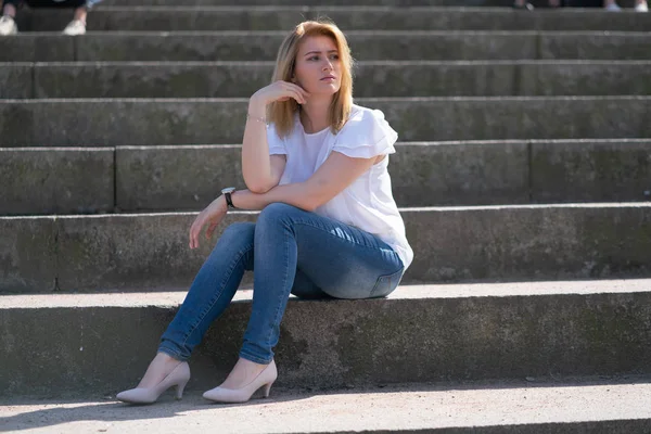 Красивая женщина расслабляется, гуляя в городском парке в джинсовой одежде — стоковое фото