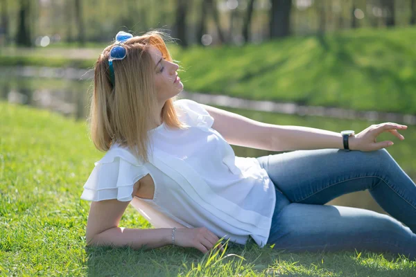 Bonita mujer relajándose caminando en el parque de la ciudad en traje de vaqueros —  Fotos de Stock