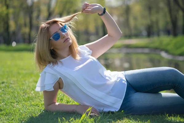 kot kıyafeti şehir parkında yürüyerek rahatlatıcı güzel kadın