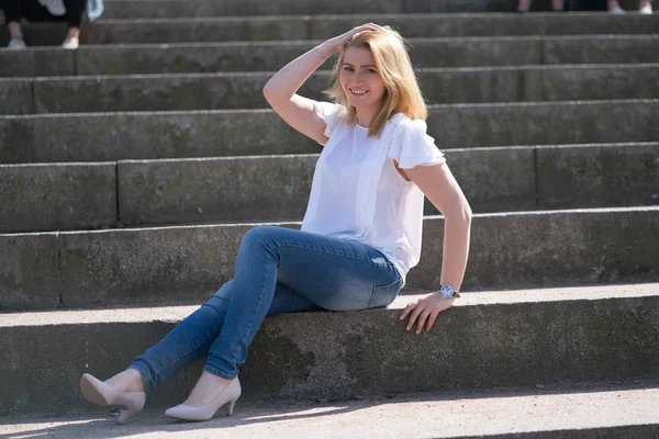 Hübsche Frau entspannt beim Spaziergang im Stadtpark im Jeans-Outfit lizenzfreie Stockfotos