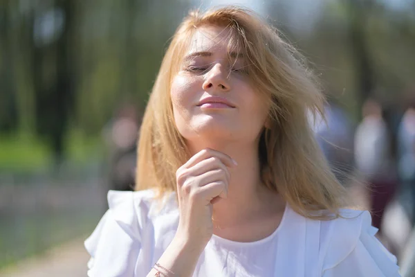 Mignonne heureuse fille blonde caucasienne avec bob coupe de cheveux dans le parc de la ville en plein air — Photo